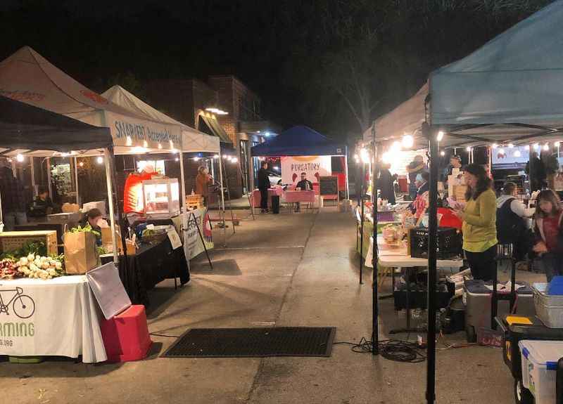 a street market with people walking around it