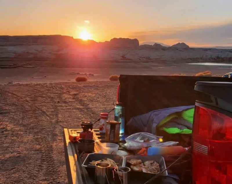 truck with a camper's bed and tent in the back