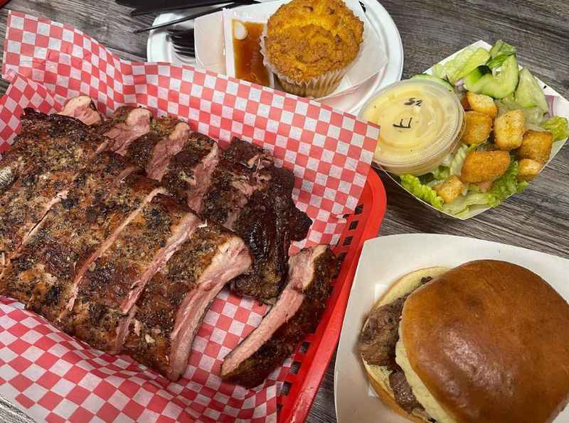 a table with a large piece of bbq and a burger