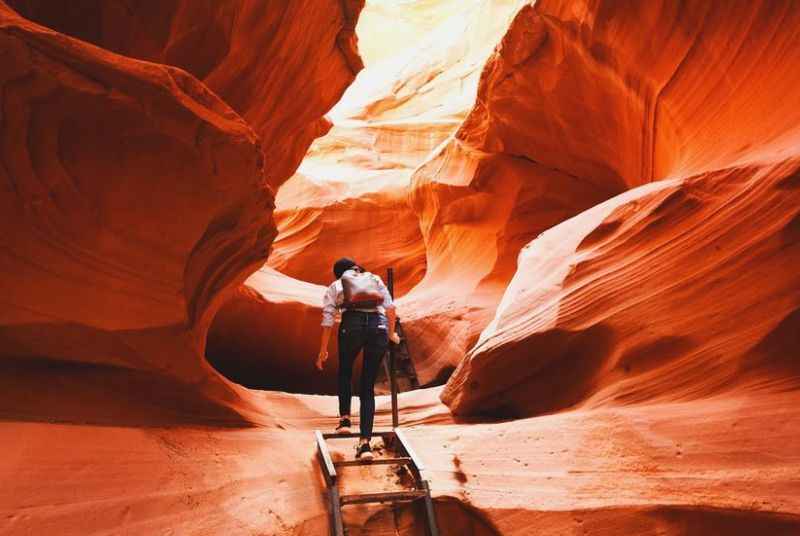 a man standing in the middle of Red colored canyon rock