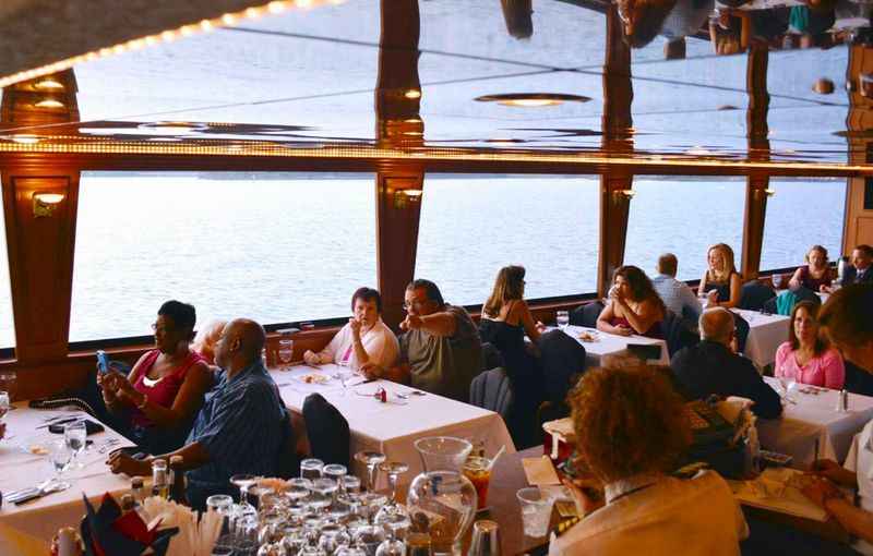 people sitting at tables in a restaurant of a cruise