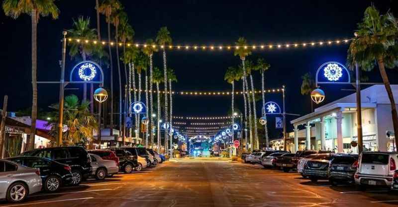 a street lined with palm trees and lights