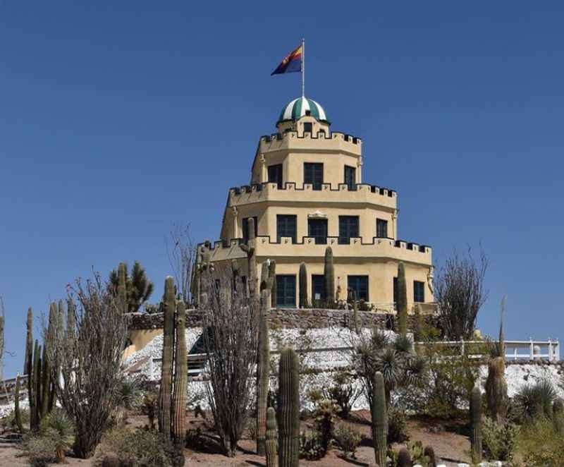 castle painted with yellow color and has flag on top