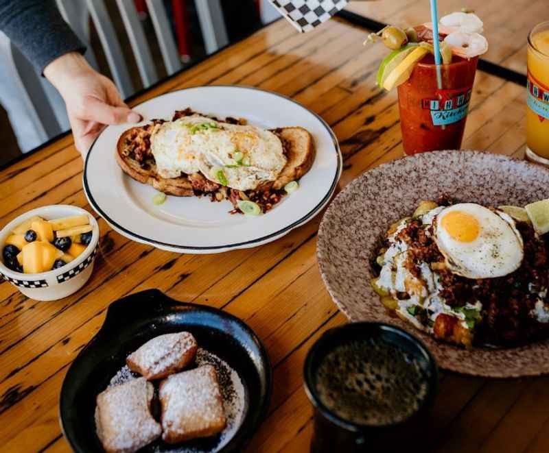 table with plates full of food with eggs on top