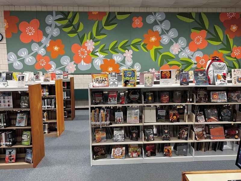 a classroom with wall mural of flowers with different books