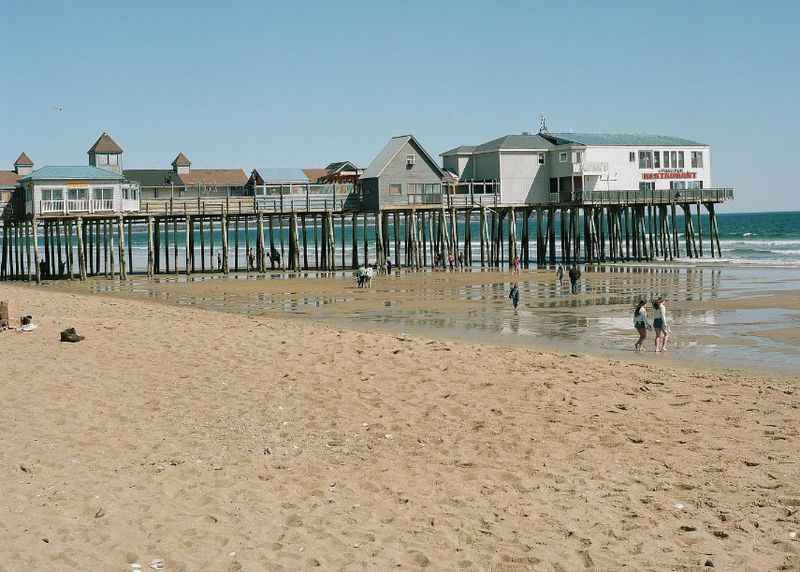 a sandy brown beach with houses build on the shore