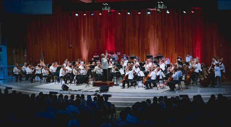 group of people sitting on the stage performs music