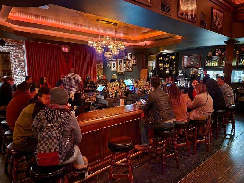 people sitting at a bar under the red lights