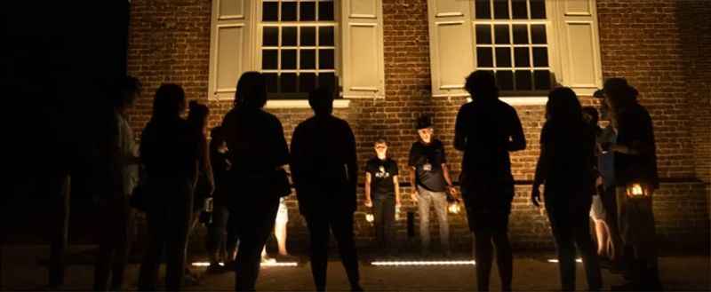 people standing in front of a building at night