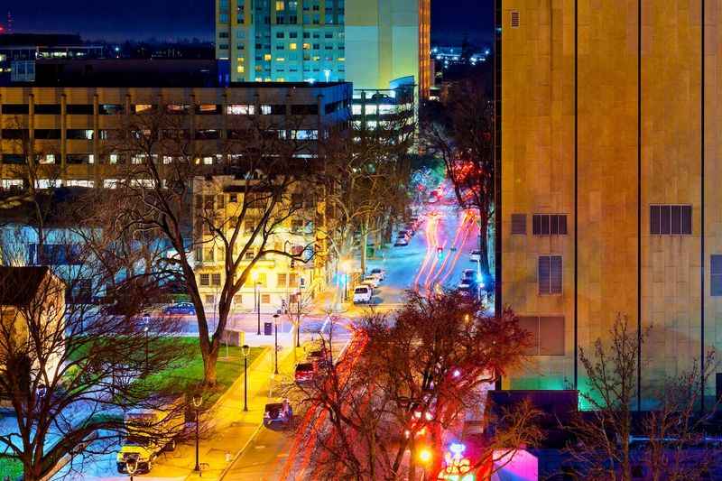 a city street at night with cars and buildings