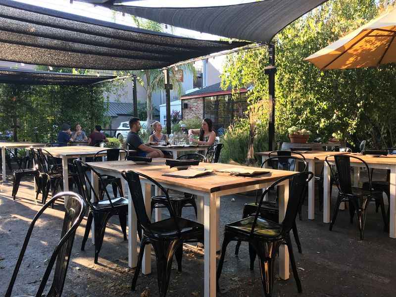 a restaurant with tables and chairs under an umbrella