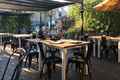 a restaurant with tables and chairs under an umbrella