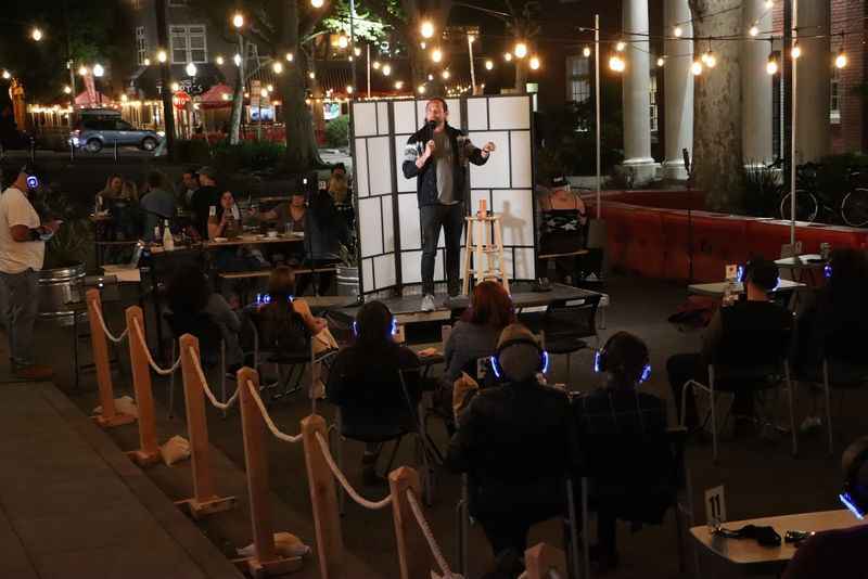 a man standing on a stage in front of a crowd