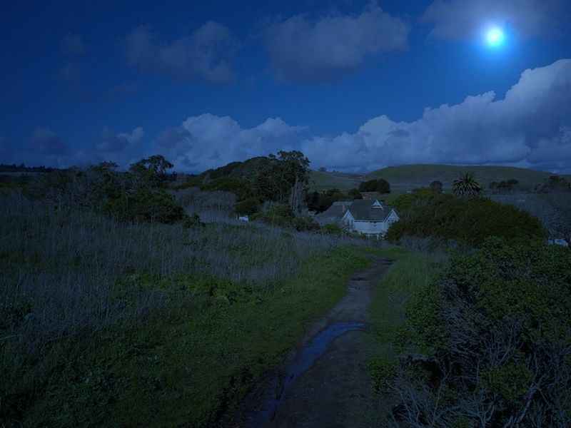 a full moon shines over a small village