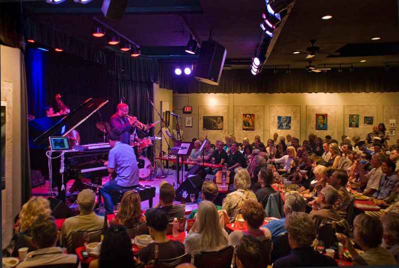 a band playing in a crowded room with a crowd