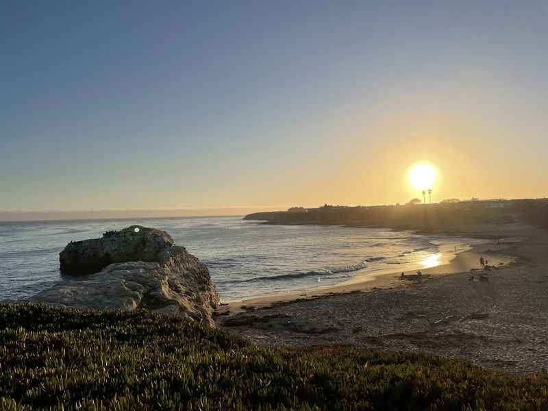 a beach with a rock and a body of water