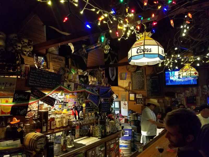 a bar with a bunch of lights hanging from the ceiling