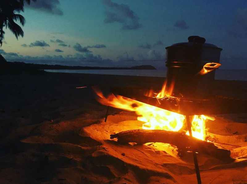 a campfire on the beach at night