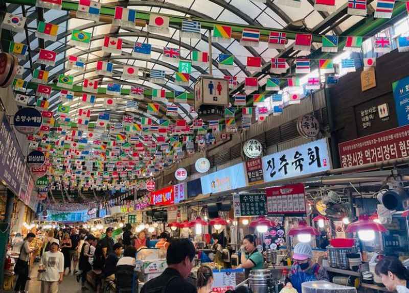 the inside of a market with flags hanging from the ceiling