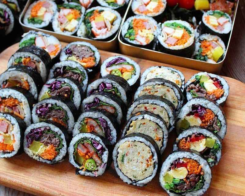 a wooden cutting board topped with Sushi rolls