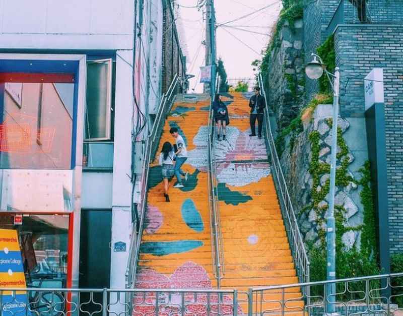 a stairway with colorful stairs and graffiti painted on it