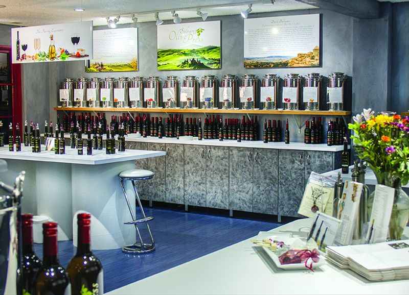 a bunch of bottles of olive oil on a counter