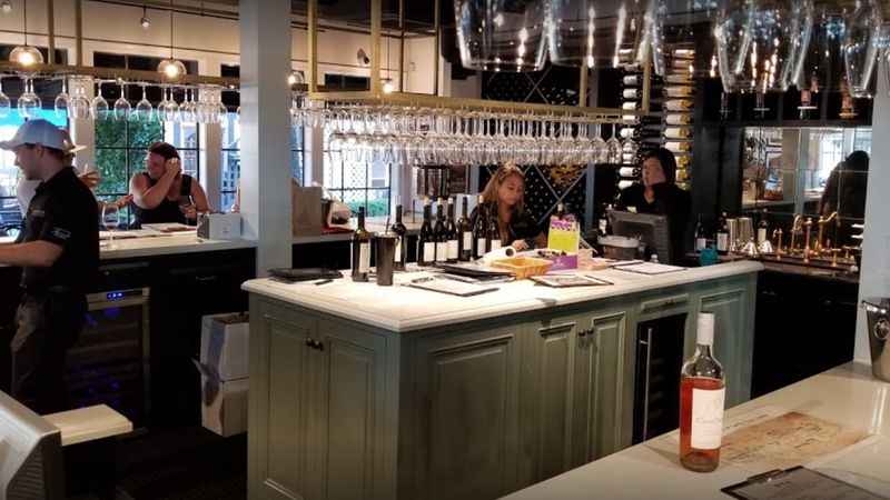 a bar with people at the counter and a bartender