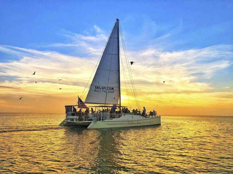 a sailer sails through the ocean at sunset