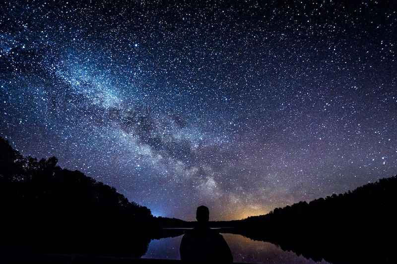 a man looking at the milky in the night sky