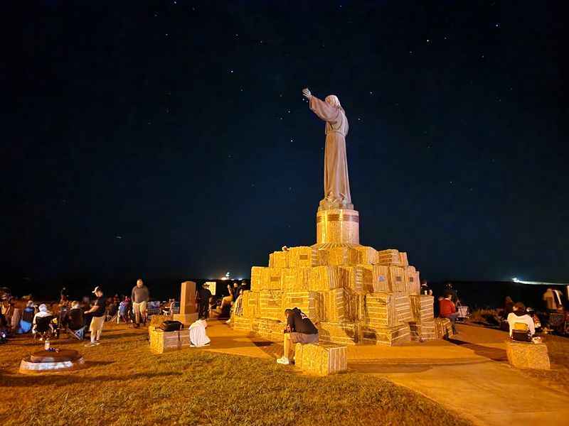 a statue of jesus on the beach at night