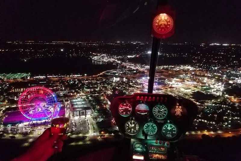 a person flying a helicopter over a city at night