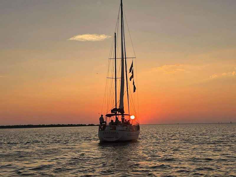 a boat is sailing in the ocean at sunset