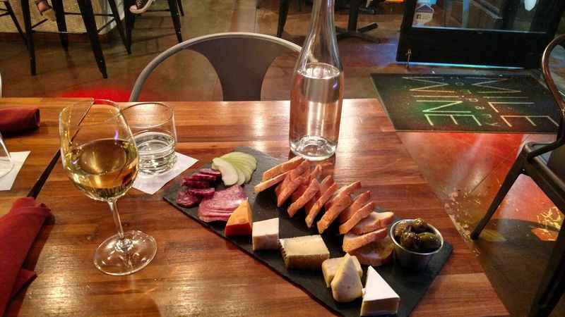 a table with a wine glass and a plate of food