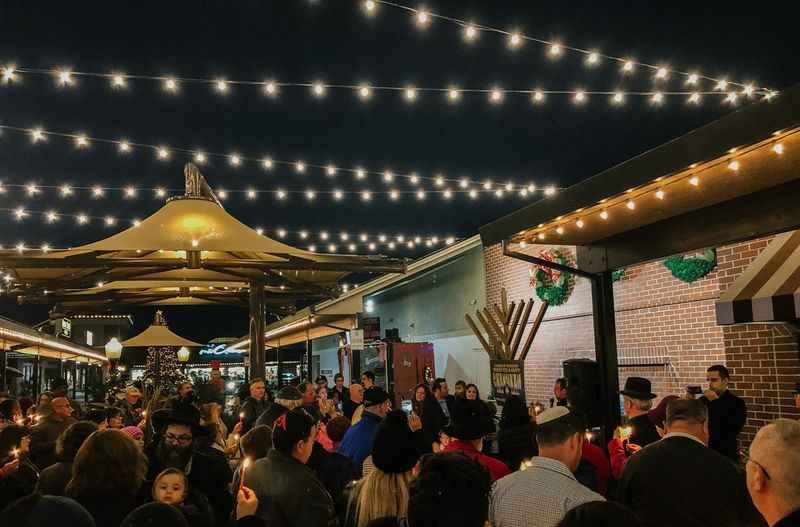 a crowd of people standing outside of a restaurant