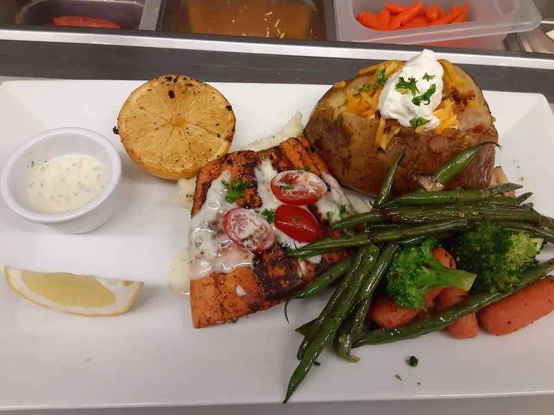 a plate with a meal of vegetables, fish and potatoes