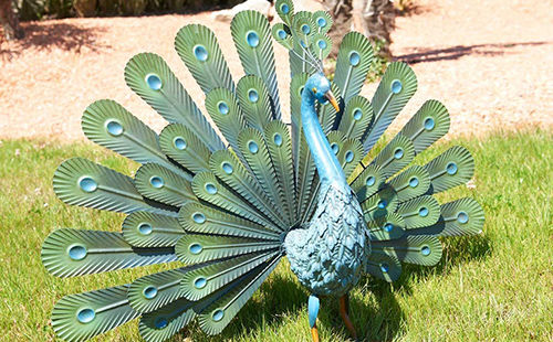 Paon en métal posé sur une pelouse