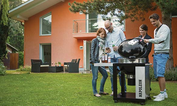 4 personnes dans un jardin autour d'un barbecue à charbon