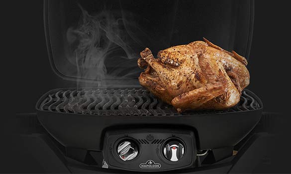 Poulet entier en train de cuire dans un barbecue électrique