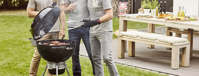 Personnes utilisant un barbecue weber à charbon à couvercle