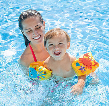 Femme et bébé avec des brassards dans une piscine