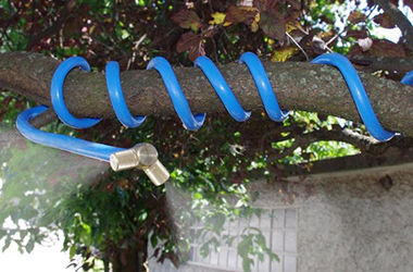 Brumisateur souple enroulé autour d'une branche d'arbre