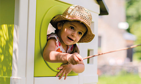 Enfant passant par la fenêtre d'une cabane de jeu