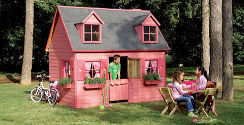 Cabane en bois rose et grise avec enfants jouant