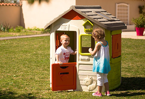 Deux enfants jouent dans une cabane en plastique Smoby