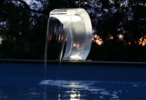 Cascade de piscine éclairée installée sur le bord de la piscine
