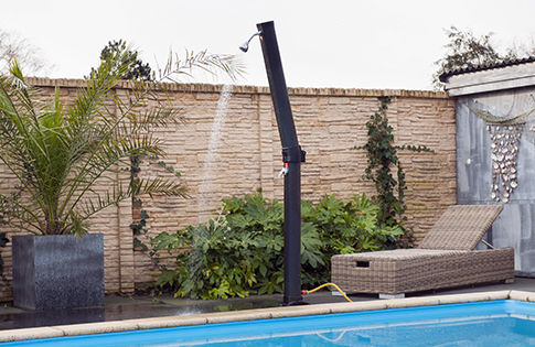 Douche de piscine en fonctionnement au bord d'une piscine