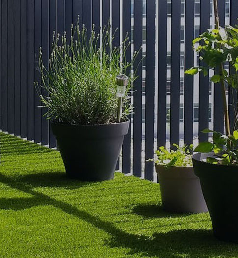 Gazon synthétique sur une terrasse avec plantes en pot