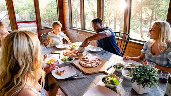 Famille découpant des pizzas sur une table