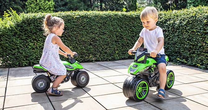 Enfants sur des porteurs jouets en forme de moto