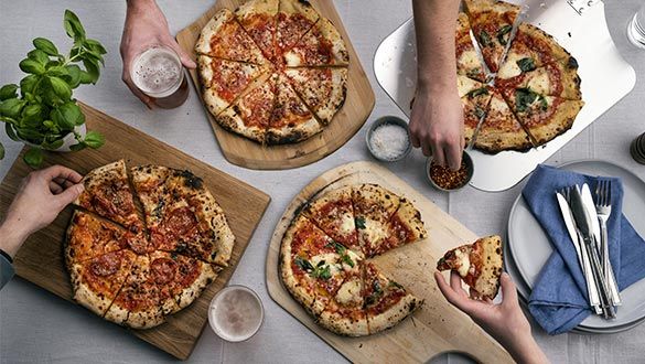 Plusieurs pizzas découpées sur une table